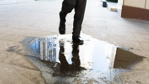 Businessman walking through a puddle Video stock 104071001