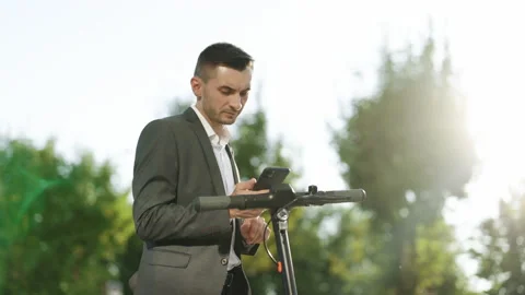 Businessman walking towards his e-scooter. Tourist man take electric scooter in Stock Footage 194601113