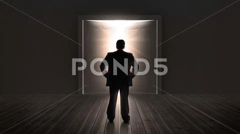Businessman watching doors opening to a bright light Stock Photos