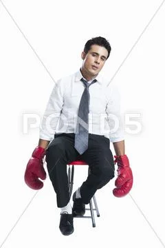 Businessman wearing boxing gloves and looking sad Stock Photos