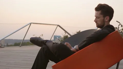 Businessman wearing a suit using a tablet outdoors. Stockbeeldmateriaal 76049208