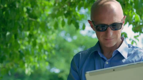 Businessman Wearing Sunglasses Using Tablet Outdoors in Nature Stock Footage 339034206
