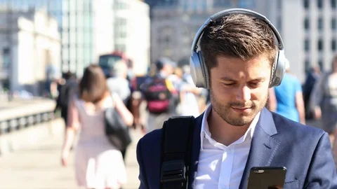 Businessman Wearing Wireless Headphones Walking To Work In Slow Motion Stock Footage