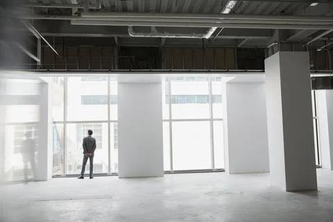 Businessman at window of empty office space Foto stock