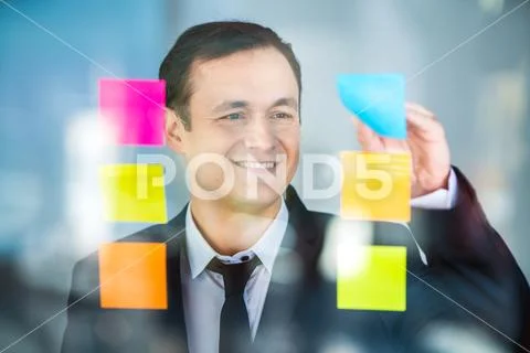 The businessman work with stickers on the window Stock Photos