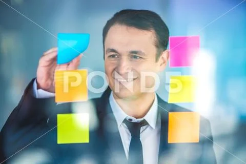 The businessman work with stickers on the window Stock Photos
