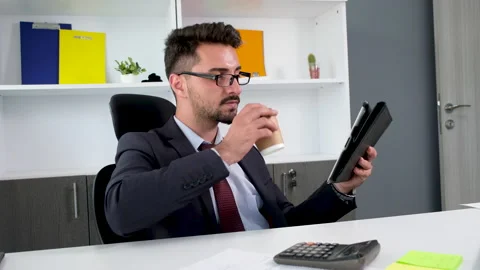 Businessman worker drinking coffee while using digital tablet Stock Footage 156945700