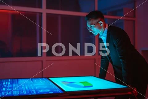 The businessman working with big displays in the dark room Stock Photos