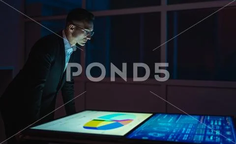 The businessman working with big screens in the dark room Stock Photos