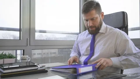 Businessman working, browsing document, data, files, in ring binder in office Vidéo 73169752