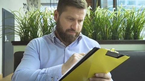 Businessman working, browsing documents, in cafe, close steadicam portrait 库存影片 73299701