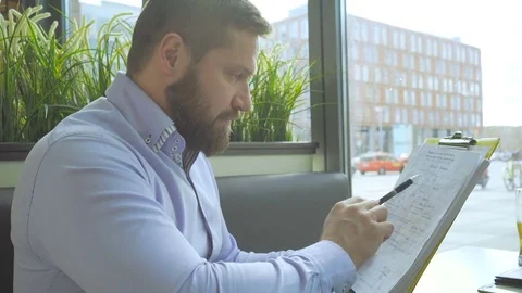 Businessman working, browsing documents, files, in cafe, close profile steadicam 库存影片 73299500