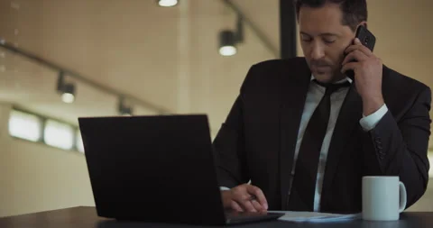 A businessman working on a computer and signing some documents Stock Footage 140202105