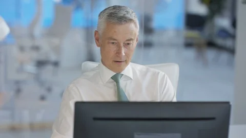 Businessman working on computer and smiling at camera in office Stock Footage 108099627