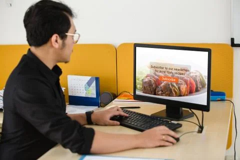Businessman working on computer doing subscribe food blog on screen at office Stock Photos