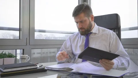 Businessman working with document, data, in ring binder and tablet, office 库存影片 73169913