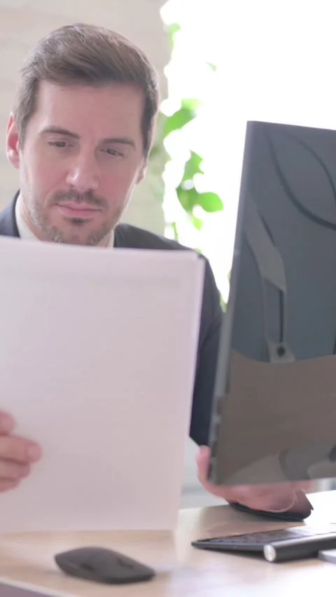 Businessman Working on Documents and Computer at Work, vertical video Stock Footage 328977576