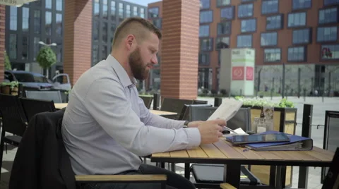 Businessman working with documents in cafe, steadicam. Vidéo 66331690