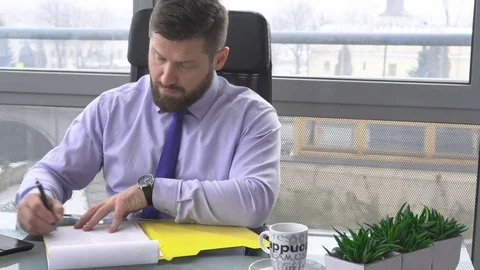 Businessman working with documents, looking at camera, in office, dolly Vidéo 73170508