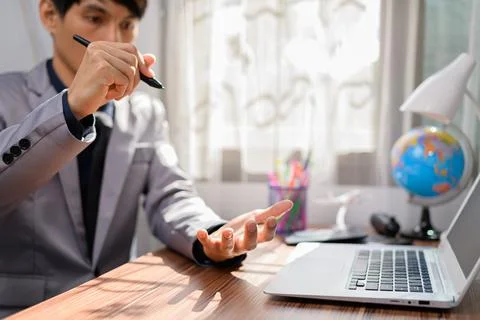 Businessman working in front of a notebook computer at a desk Foto stock