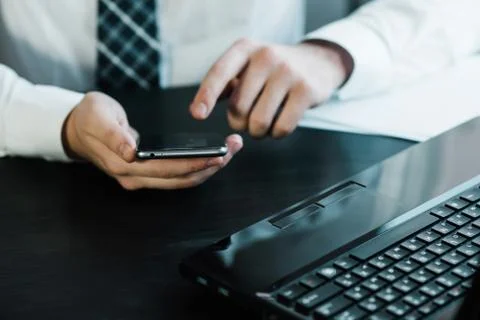Businessman working with generic design notebook. Holding smartphone in hands Foto stock