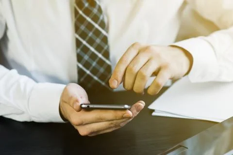 Businessman working with generic design notebook. Holding smartphone in hands 库存照片