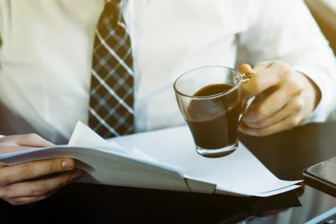 Businessman working with generic design notebook. Holding smartphone in hands Фото