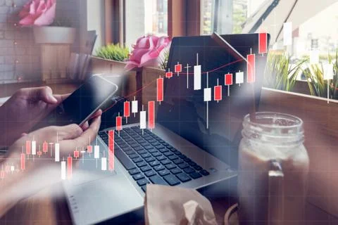Businessman is working with his computer in coffee shop with stock chart an.. Stock Photos