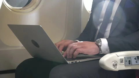 Businessman working on laptop computer sitting inside an airplane with sun li Stock Footage 147239328