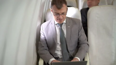 Businessman working on laptop computer sitting inside an airplane Stock Footage 167049897