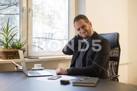 Businessman working on laptop in office neck hurt Stock Photos