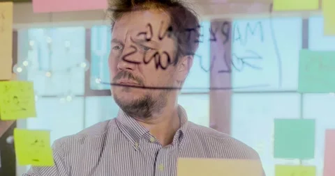 Businessman working with notes on glass wall Vídeo Stock 324572831