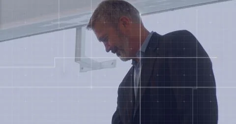 Businessman working in office with data processing image over grid background Foto stock