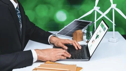 Businessman working in office developing plan on alternative energy. Gyre Stock Photos