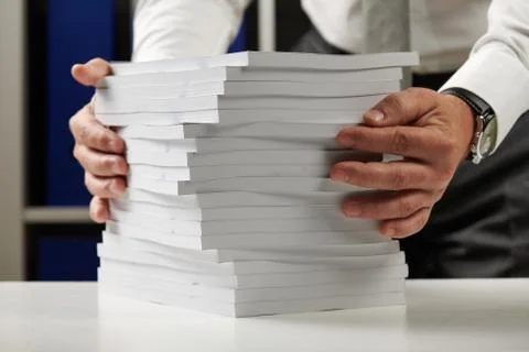 Businessman working at an office, reads stack of books and reports. Business  Foto stock