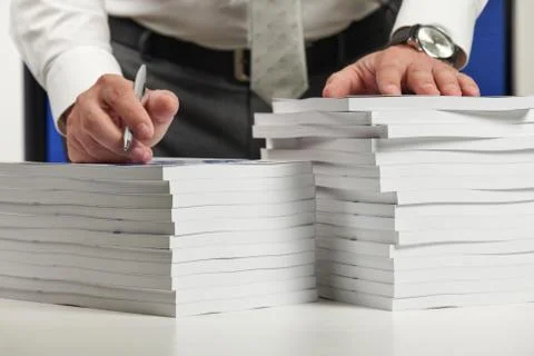 Businessman working at an office, reads stack of books and reports. Business  Stock Photos