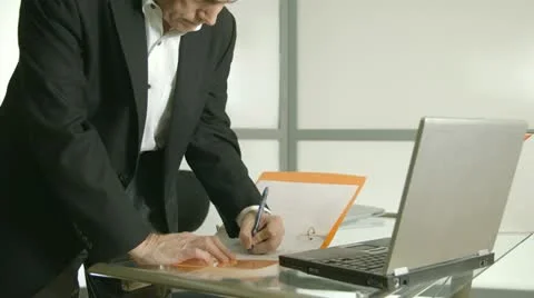 Businessman working on paperwork walks off Stock Footage