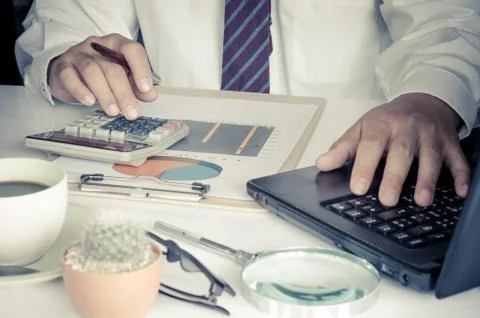Businessman is working on a table with a functional device is placed. 库存照片