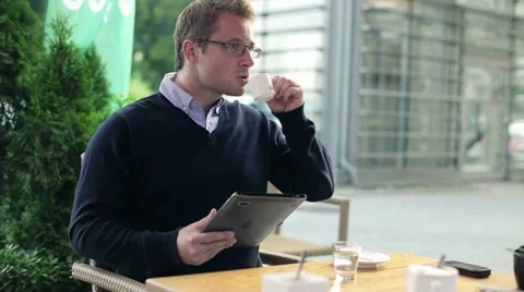 Businessman working on tablet computer and drinking coffee in cafe HD Stock Footage 11874525