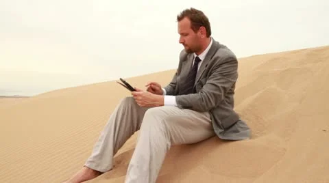 Businessman working on tablet computer in the desert Stockbeeldmateriaal 10839899