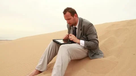 Businessman working on tablet computer in the desert Stock Footage 10848510