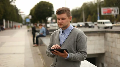 Businessman working on tablet computer by the street, 1080p Stock Footage 28505214
