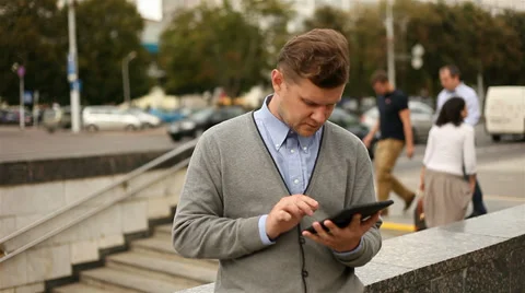 Businessman working on tablet computer by the street, 1080p Stock Footage 28505282