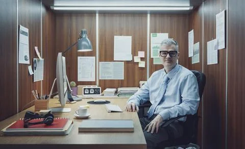 Businessman working in a tiny office Stock Photos