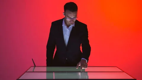 The businessman working with a touchscreen in the red room Stock Footage 100564496