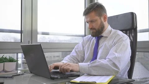 Businessman working, writing on laptop computer, ask for a cup of coffee, office 库存影片 73169641