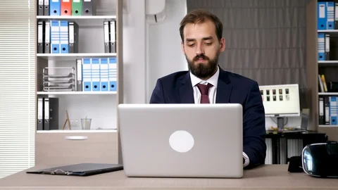 Businessman works on the computer than picks up a VR headset Stock Footage 95231053