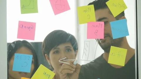 Businessman Write and Discuss Graphs On The Glass Board Video stock 93698452