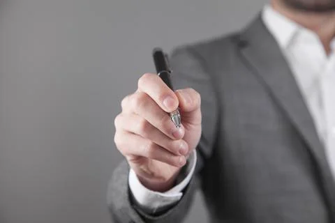 Businessman writes with a pen in empty screen. Stock Photos