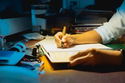 Businessman writing on document while working late in office. Stock Photos